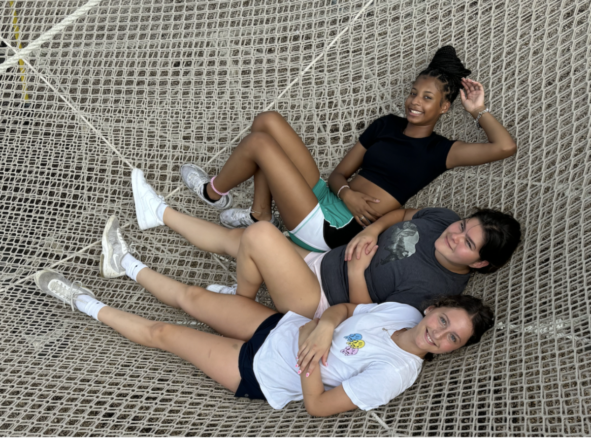 Freshmen KayKay Jeff, Noa Weber, and Kate Elterman lay on a net hammock during their retreat.